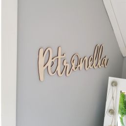 Väggdekor i trä med egen text.