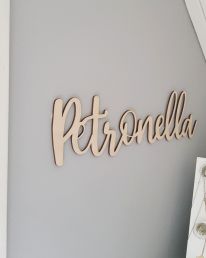 Väggdekor i trä med egen text.